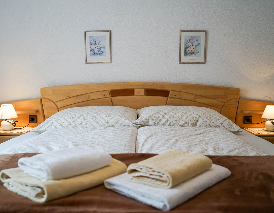 gaestehaus-fischer-doppelzimmer-blick-aufs-bett-c-tvb-wipptal-laura-ribis